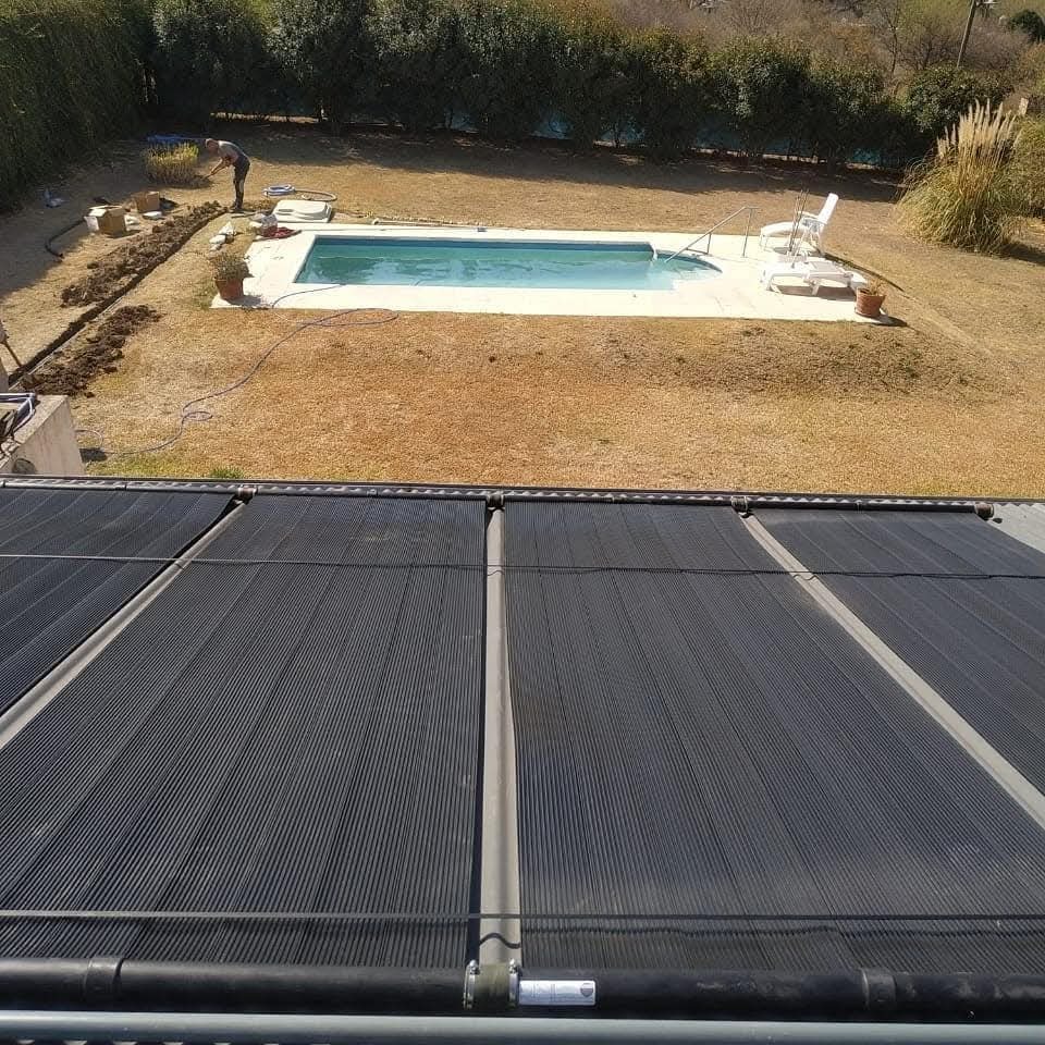 Captadores solares de climatización sobre techo con vista a la piscina de la propiedad.